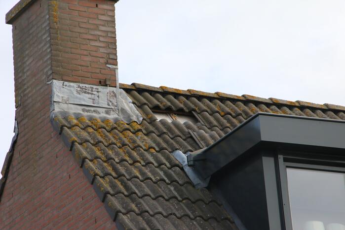 Brandweer legt weggewaaide dakpannen terug