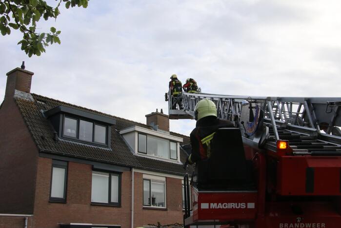 Brandweer legt weggewaaide dakpannen terug