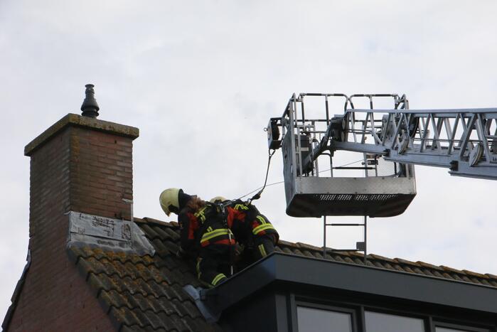 Brandweer legt weggewaaide dakpannen terug
