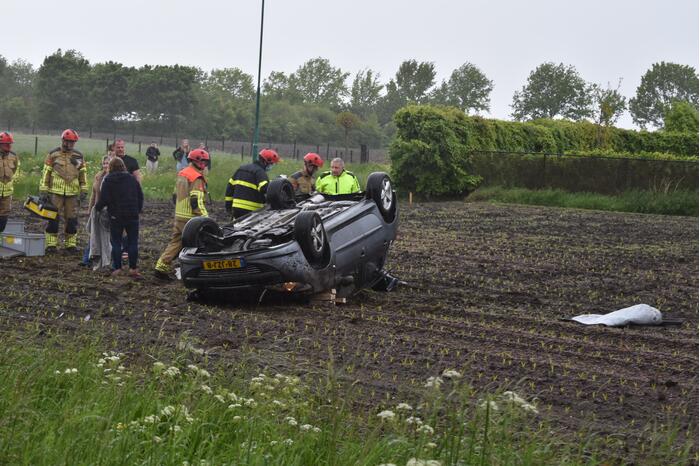 Auto op z'n kop in weiland
