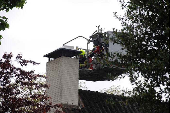 Brandweer blust brand in schoorsteen