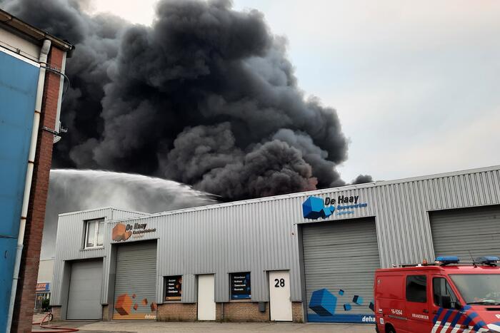 Dikke zwarte rookwolken bij uitslaande brand