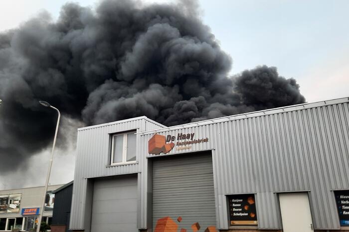 Dikke zwarte rookwolken bij uitslaande brand