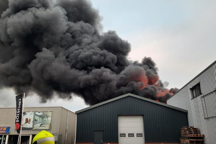 Dikke zwarte rookwolken bij uitslaande brand
