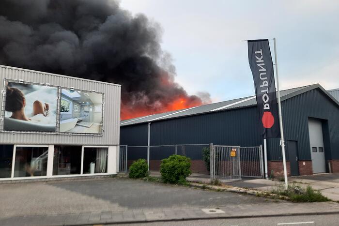Dikke zwarte rookwolken bij uitslaande brand