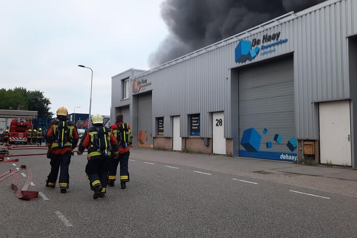 Dikke zwarte rookwolken bij uitslaande brand