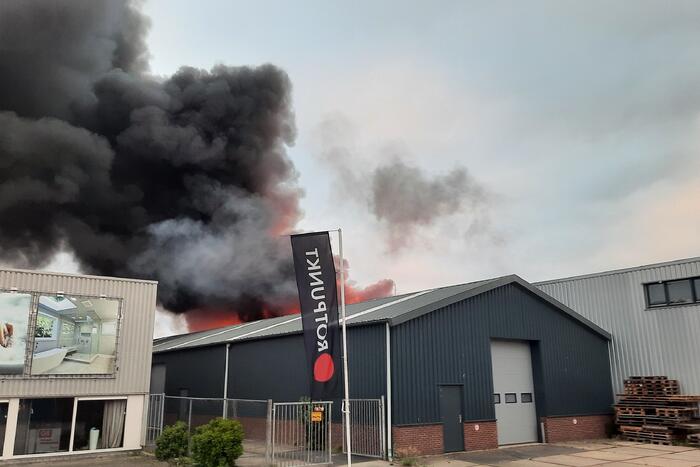 Dikke zwarte rookwolken bij uitslaande brand