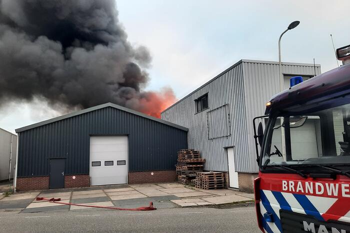 Dikke zwarte rookwolken bij uitslaande brand