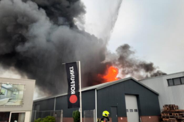 Dikke zwarte rookwolken bij uitslaande brand