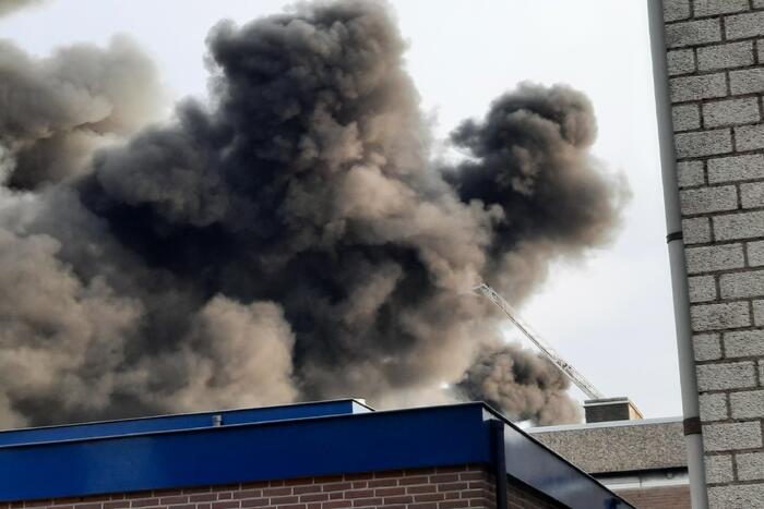 Dikke zwarte rookwolken bij uitslaande brand