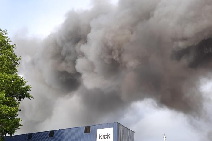 Dikke zwarte rookwolken bij uitslaande brand