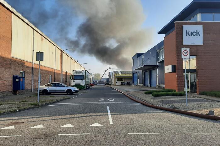 Dikke zwarte rookwolken bij uitslaande brand