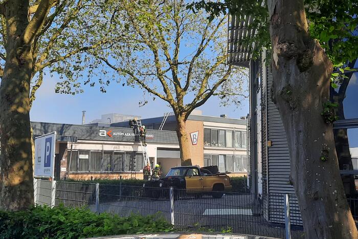 Dikke zwarte rookwolken bij uitslaande brand