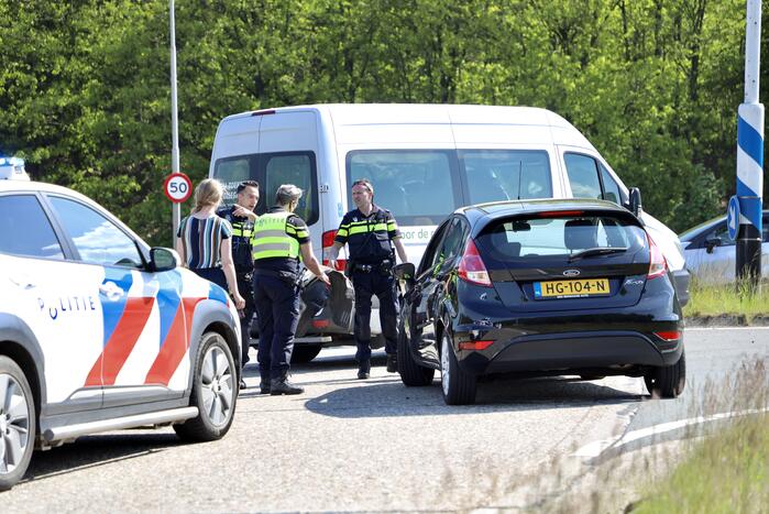 Auto botst op taxibus op rotonde