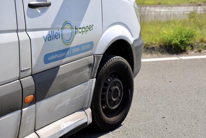 Auto botst op taxibus op rotonde