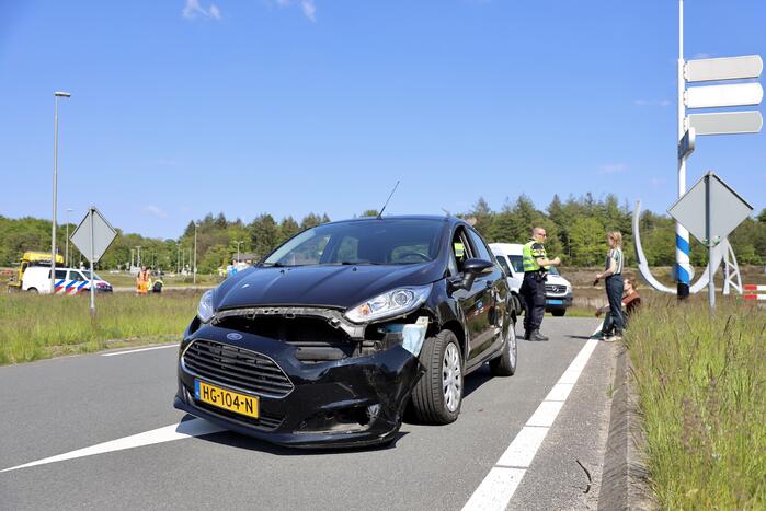 Auto botst op taxibus op rotonde
