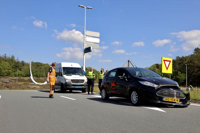 Auto botst op taxibus op rotonde