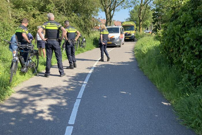 Vrouw gaat met fiets onderuit