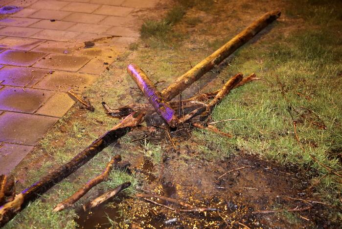 Brandweer blust brandende stukken hout