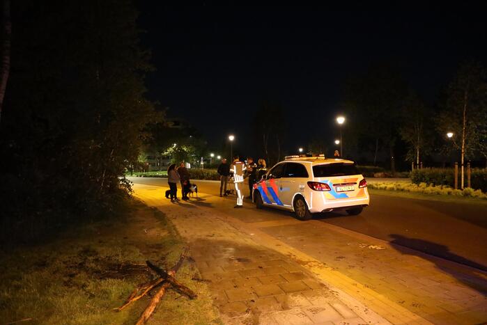 Brandweer blust brandende stukken hout