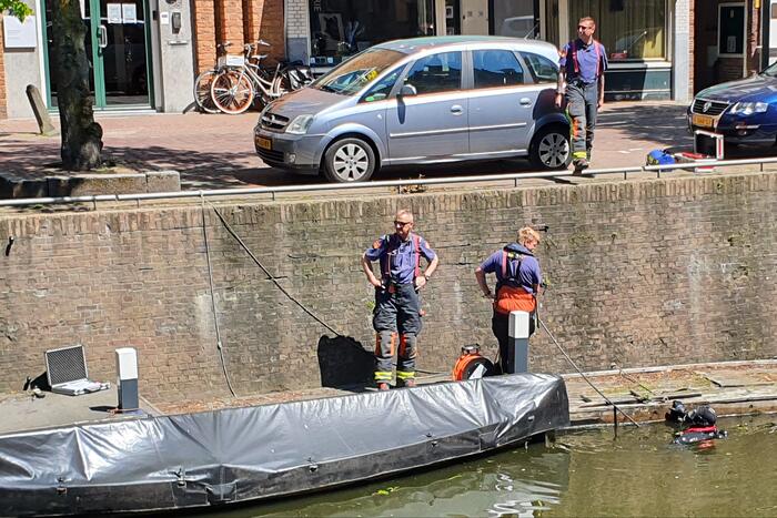 Zoektocht in gracht naar verloren bos sleutels