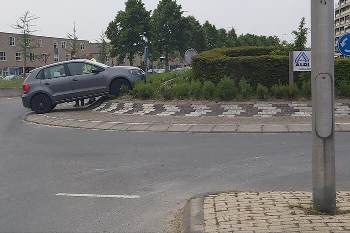Automobilist rijdt met auto de rotonde op