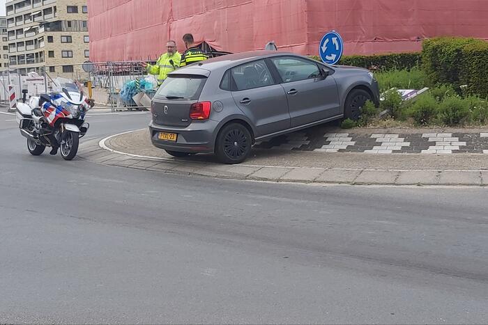 Automobilist rijdt met auto de rotonde op