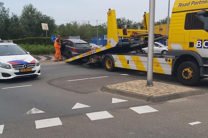 Automobilist rijdt met auto de rotonde op