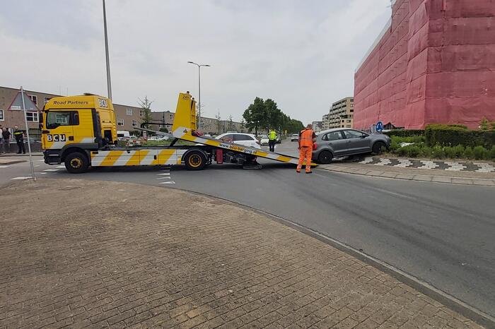 Automobilist rijdt met auto de rotonde op
