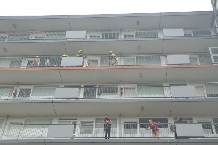 Brandweer blust brandende wasdroger in appartement