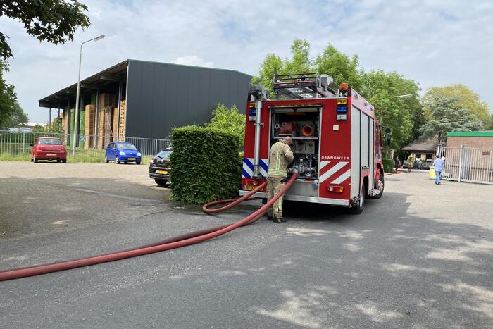 Brandweer blust brandende container met houtpulp bij houtbedrijf Rowood