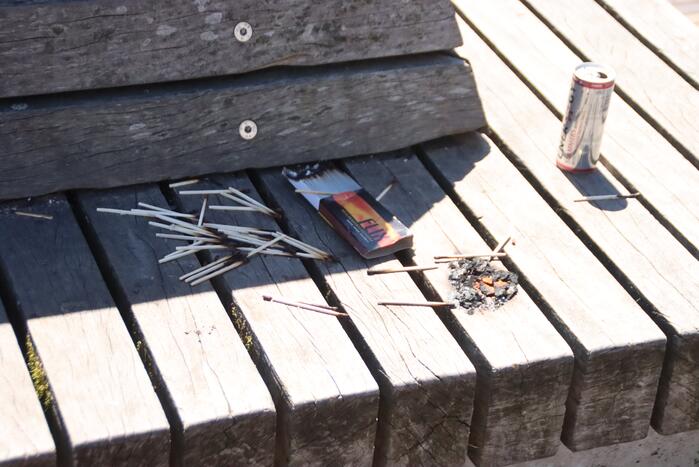 Brandgesticht op houten bank