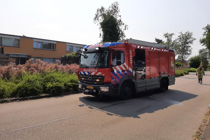 Brandweer blust in brand staande schutting