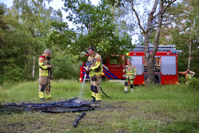 Stapel houten takken in brand in bosgebied De Bergjes