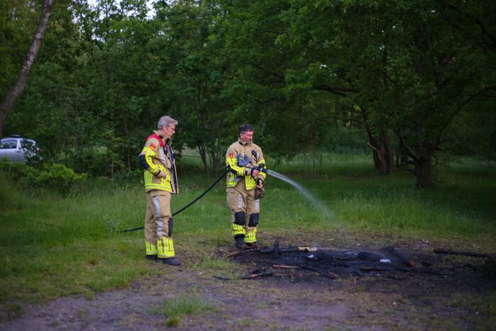 Stapel houten takken in brand in bosgebied De Bergjes