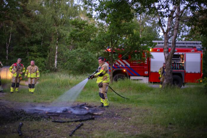 Stapel houten takken in brand in bosgebied De Bergjes