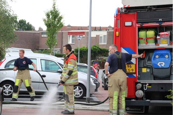 Brandweer blust in brand gestoken container