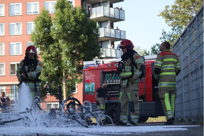 Brandweer blust brandende stapel fietsen