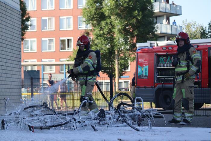Brandweer blust brandende stapel fietsen
