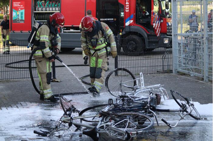 Brandweer blust brandende stapel fietsen