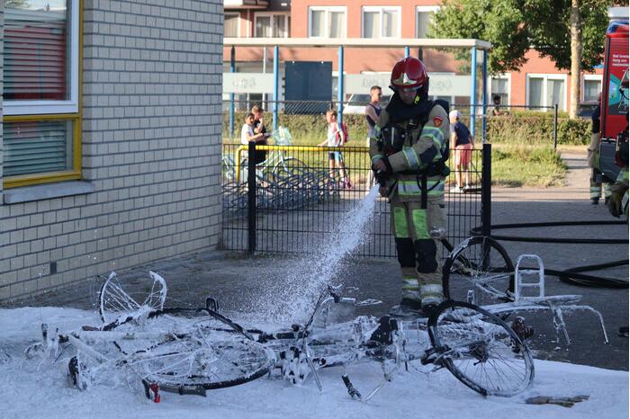 Brandweer blust brandende stapel fietsen
