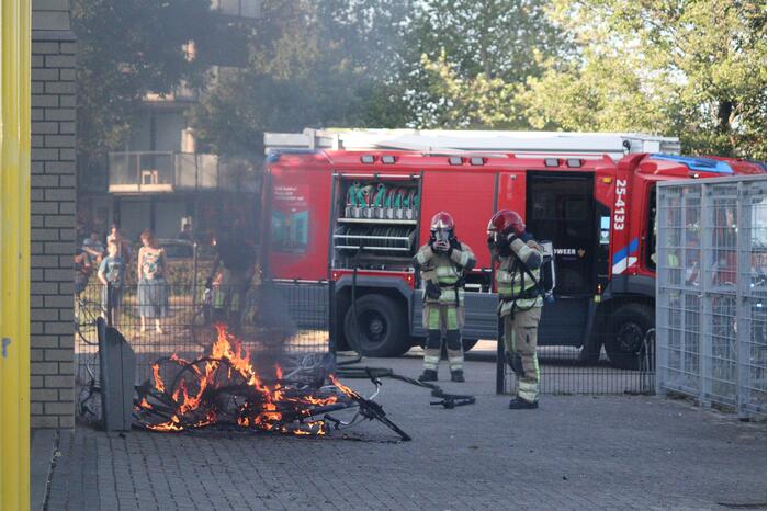 Brandweer blust brandende stapel fietsen