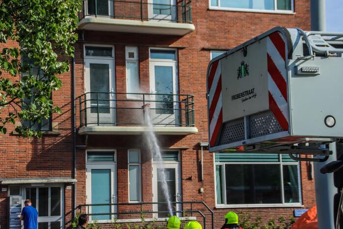 Brandweer blust brandende plant op balkon