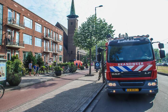 Brandweer blust brandende plant op balkon