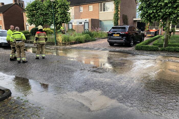 Straat onder water door gesprongen waterleiding