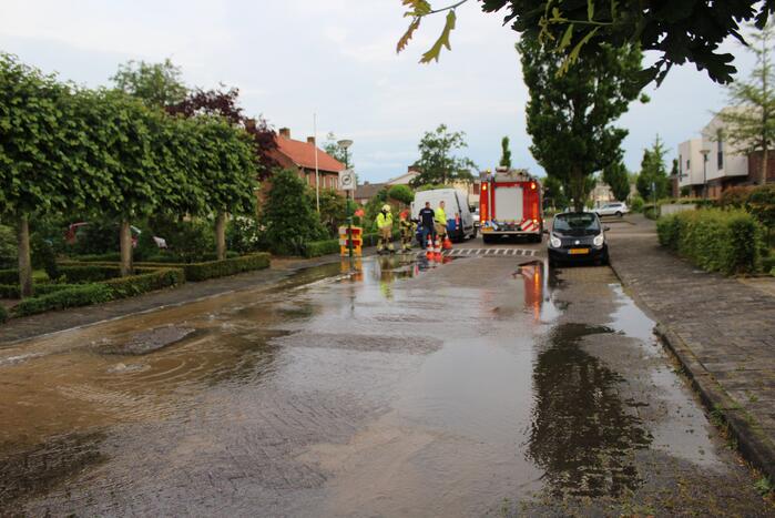 Straat onder water door gesprongen waterleiding