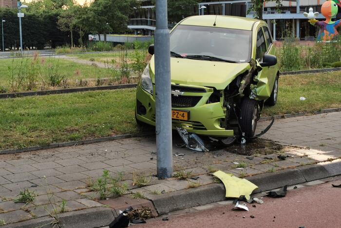 Bestuurster botst met personenauto tegen lantarenpaal