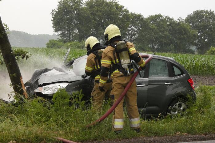 Auto vliegt in brand na botsing tegen boom