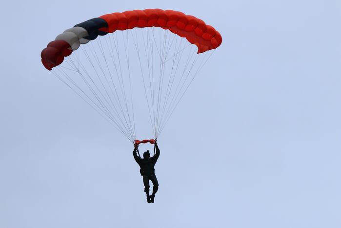 Parachutisten landen met vlag veteranendag op Malieveld