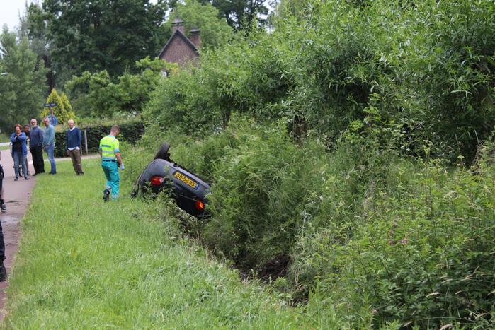Auto op zijn kop in de sloot